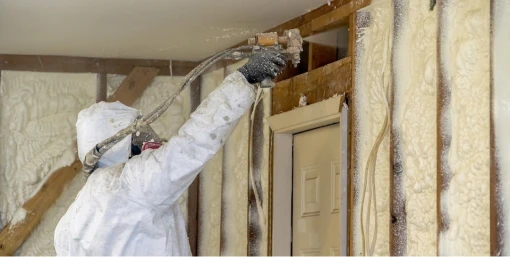 Spray foam technician applying product.